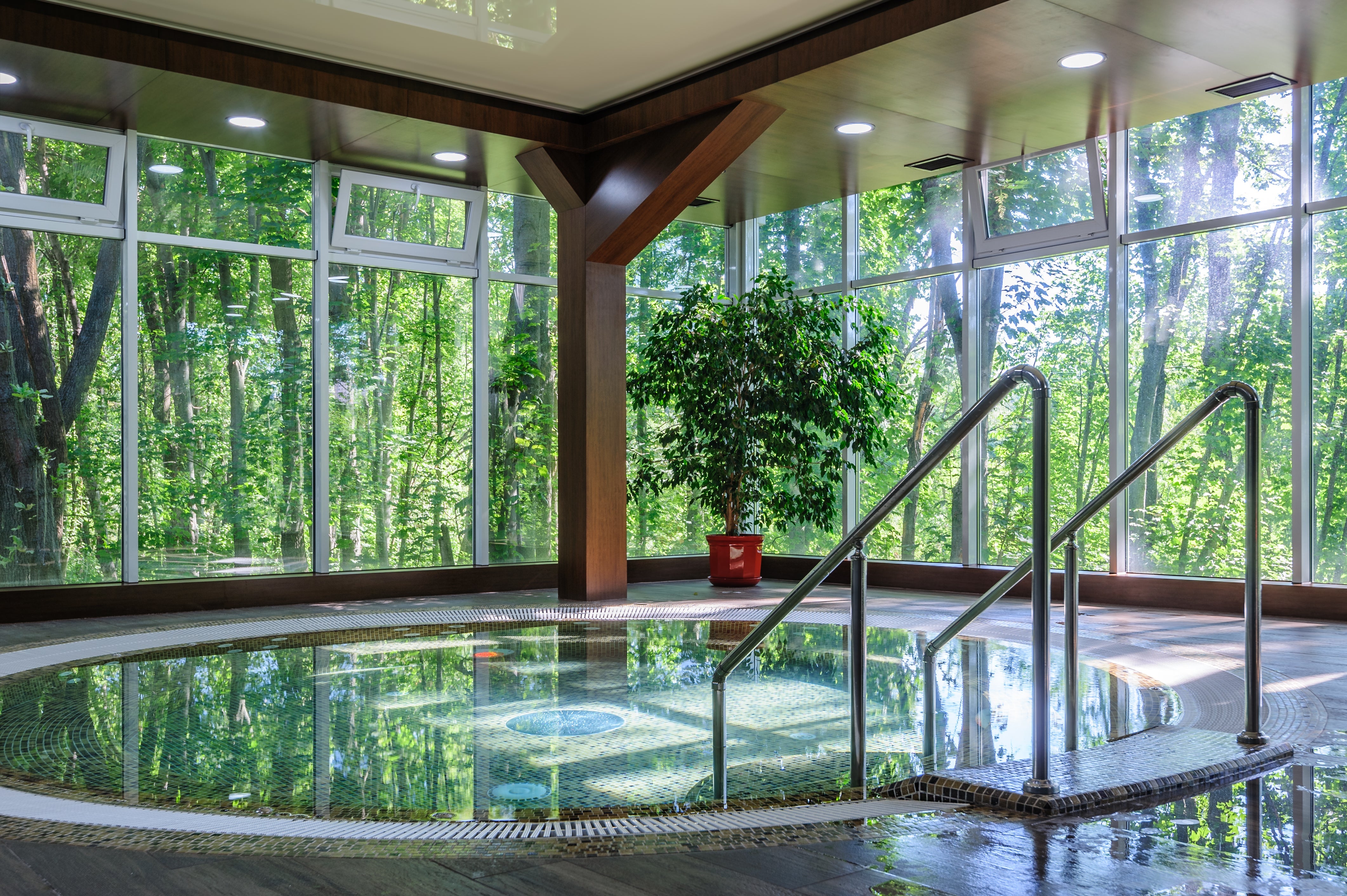 Blue mosaic hot tub tiles wrapping the benches and waterline of a luxury outdoor spa.