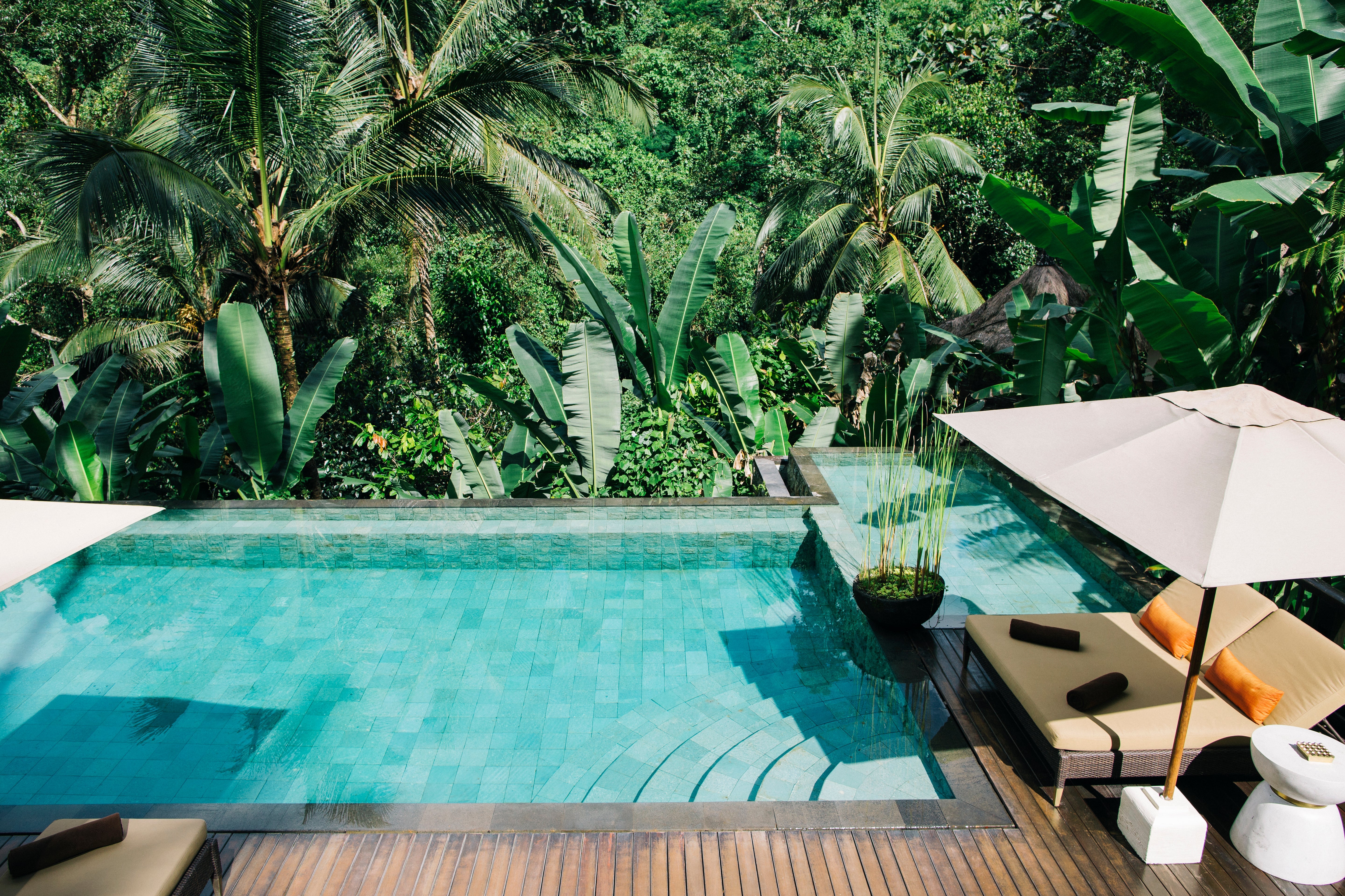 Blue mosaic ceramic tiles installed along the waterline of a bright outdoor swimming pool.