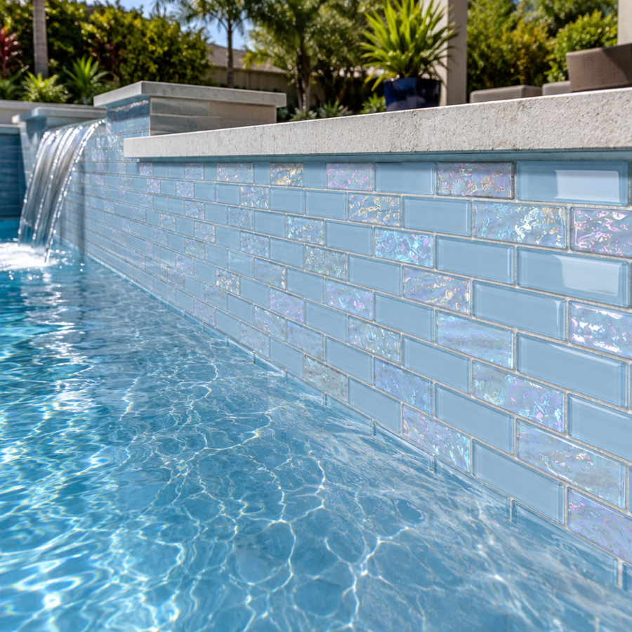 Pool waterline and waterfall wall finished in Iridescent Ocean Blue glass mosaic tile.
