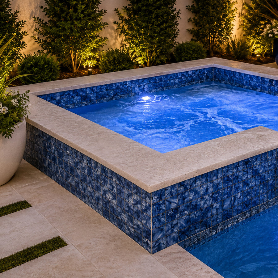 Rectangular spa lit from within, finished in Ocean Blue Artisan 6x6 porcelain tile with stone coping.