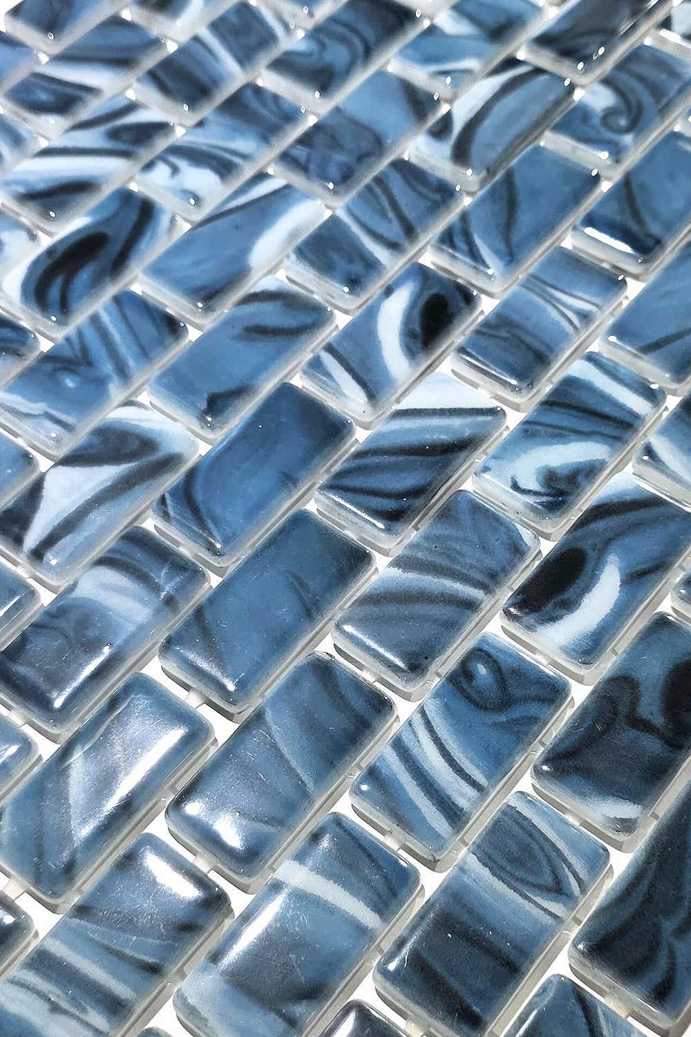 Macro close-up of Storm Blue Marble recycled glass mosaic tile showing glossy blue and white swirled chips.