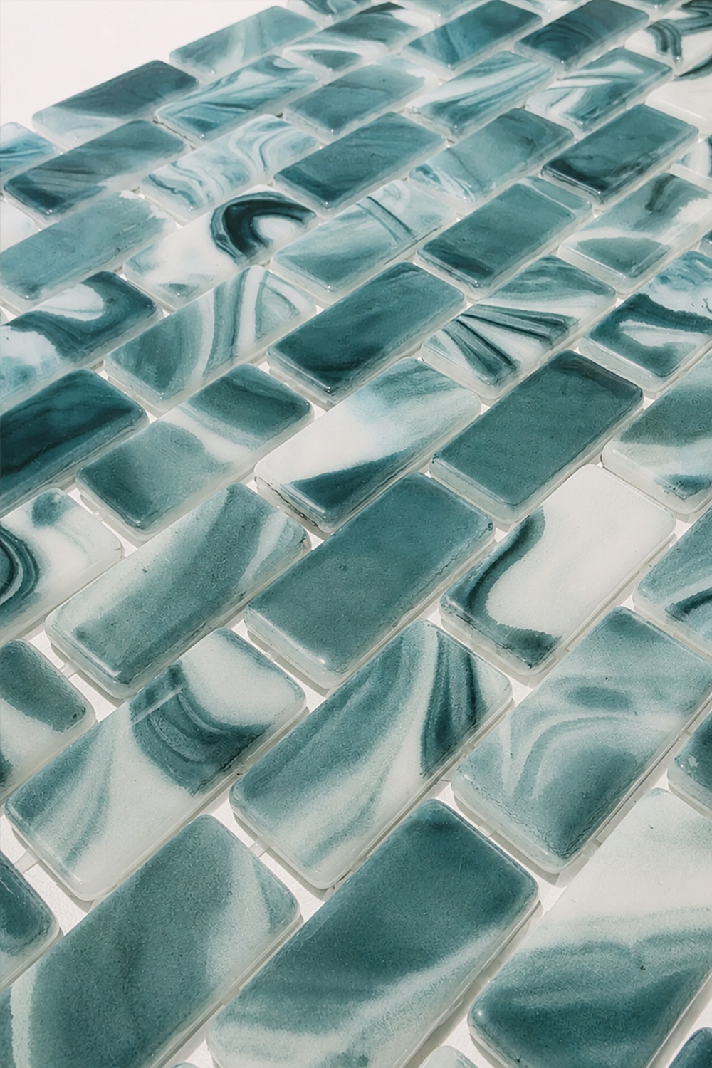 Close-up of Seafoam Green Swirl recycled glass mosaic tile showing glossy green and white swirled rectangular chips.