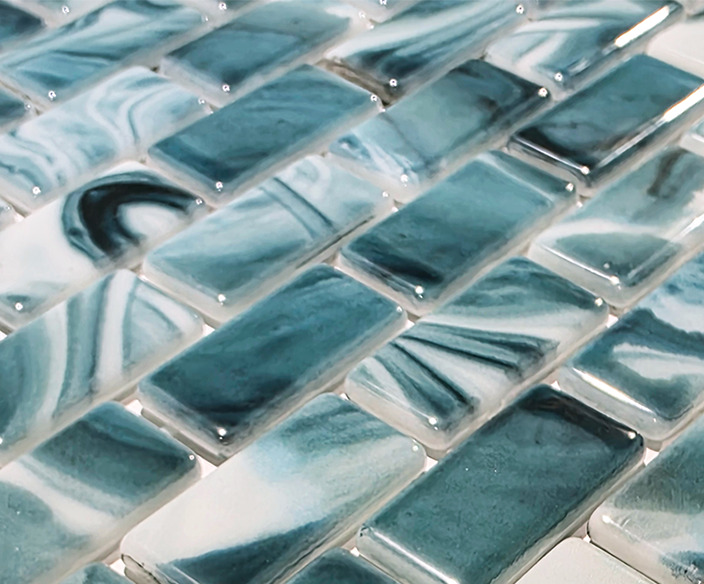 Macro close-up of Seafoam Green Swirl recycled glass mosaic showing glossy green, teal and white swirled chips.