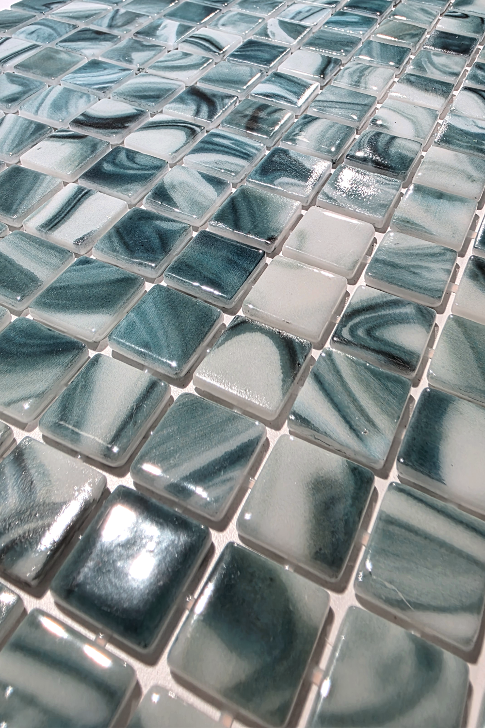 Close-up of PT-9803 glass mosaic pool tile showing glossy 1-inch chips swirled in seafoam green, aqua, teal and white.